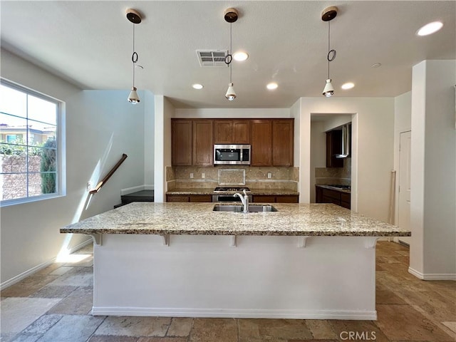 345 W Saint Andrews St, Ontario, CA 91762 - kitchen with stainless steel microwave, backsplash, light stone counters, a breakfast bar area, and recessed lighting