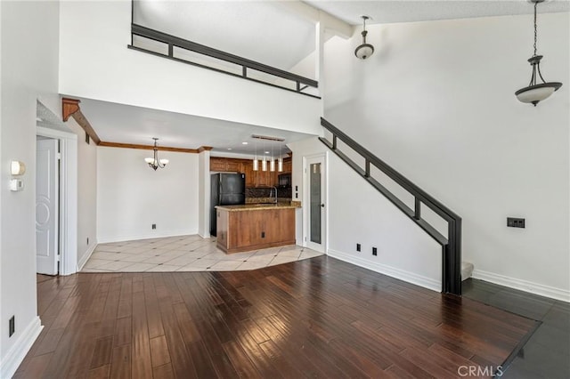13115 Le Parc Unit 40, Chino Hills, CA 91709 - unfurnished living room featuring high vaulted ceiling, a chandelier, light wood finished floors, and baseboards