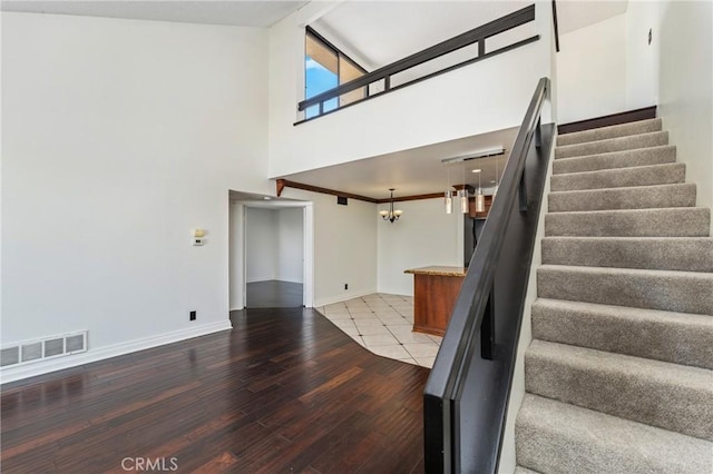 13115 Le Parc Unit 40, Chino Hills, CA 91709 - staircase with a chandelier, hardwood / wood-style flooring, a towering ceiling, and baseboards