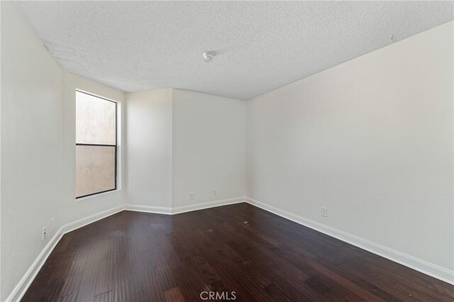 13115 Le Parc Unit 40, Chino Hills, CA 91709 - spare room with dark wood-style floors, baseboards, and a textured ceiling
