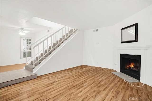 18411 Hatteras St Unit 122, Tarzana, CA 91356 - unfurnished living room featuring stairway, wood finished floors, a fireplace with flush hearth, and ceiling fan