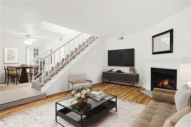 18411 Hatteras St Unit 122, Tarzana, CA 91356 - living room featuring stairway, wood finished floors, a fireplace with flush hearth, and a ceiling fan