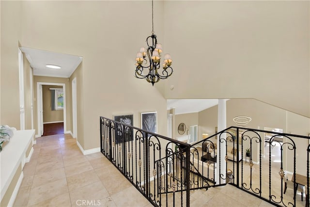 3313 Cabo Ct, Carlsbad, CA 92009 - corridor featuring a high ceiling, a chandelier, tile patterned floors, an upstairs landing, and baseboards