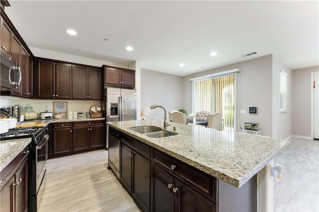 6045 Lyon St, Chino, CA 91710 - kitchen featuring a sink, appliances with stainless steel finishes, a center island with sink, recessed lighting, and light stone counters