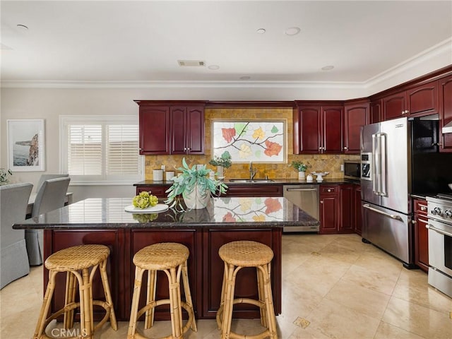 229 N Juanita Ave Unit B, Redondo Beach, CA 90277 - kitchen featuring dark brown cabinets, appliances with stainless steel finishes, crown molding, a sink, and a center island