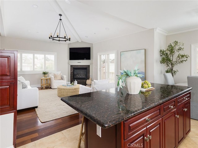 229 N Juanita Ave Unit B, Redondo Beach, CA 90277 - kitchen with reddish brown cabinets, a chandelier, a kitchen island, a high end fireplace, and pendant lighting