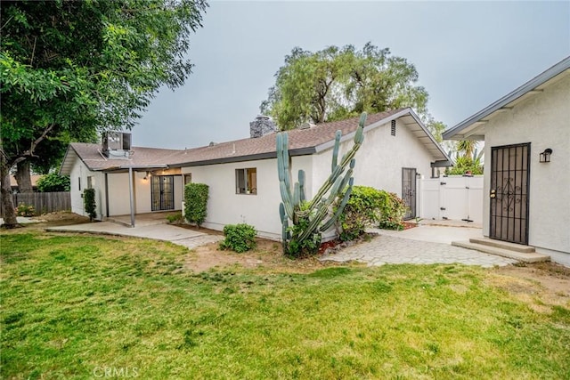 6367 Willow Ave, Rialto, CA 92377 - back of property with a patio area, stucco siding, a gate, and a chimney