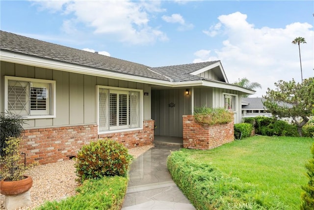 920 Wildrose, Brea, CA 92821 - doorway to property featuring board and batten siding, brick siding, a lawn, and a shingled roof