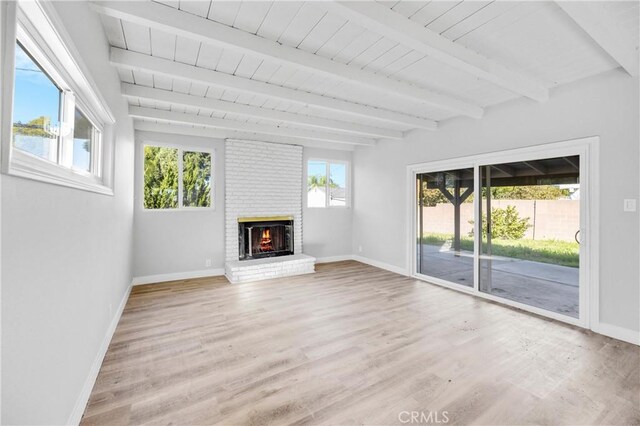 12119 Los Coyotes Ave, La Mirada, CA 90638 - unfurnished living room with light wood finished floors, a brick fireplace, and a wooden ceiling with exposed beams