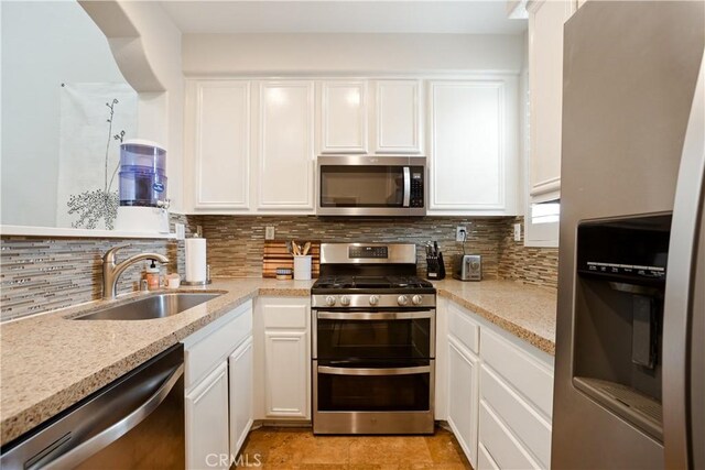 367 Caminito Barcelona, Chula Vista, CA 91914 - kitchen with stainless steel appliances, tasteful backsplash, white cabinets, and light stone countertops