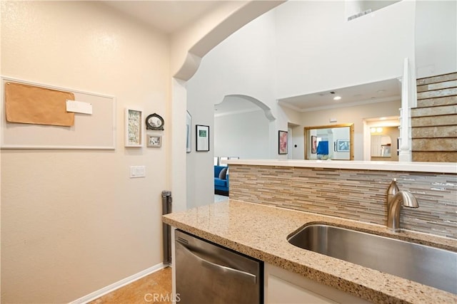 367 Caminito Barcelona, Chula Vista, CA 91914 - kitchen featuring stainless steel dishwasher, tasteful backsplash, arched walkways, light stone counters, and a high ceiling