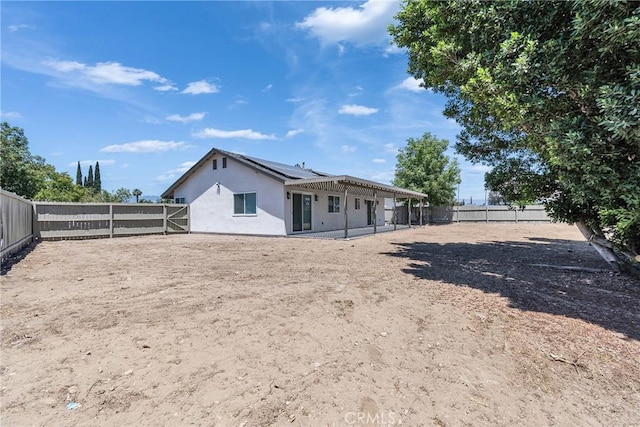 16409 Barbee St, Fontana, CA 92336 - rear view of house with stucco siding, solar panels, a fenced backyard, and a patio