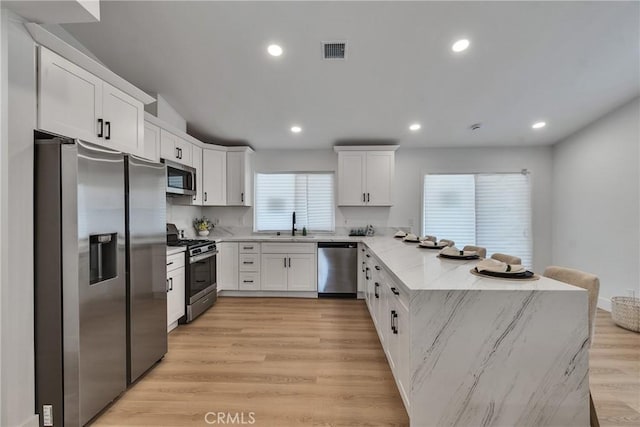 16409 Barbee St, Fontana, CA 92336 - kitchen featuring stainless steel appliances, a peninsula, white cabinetry, and recessed lighting
