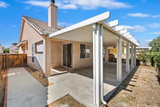 797 Camino De Plata, San Jacinto, CA 92583 - rear view of house with a chimney, a fenced backyard, ceiling fan, and stucco siding