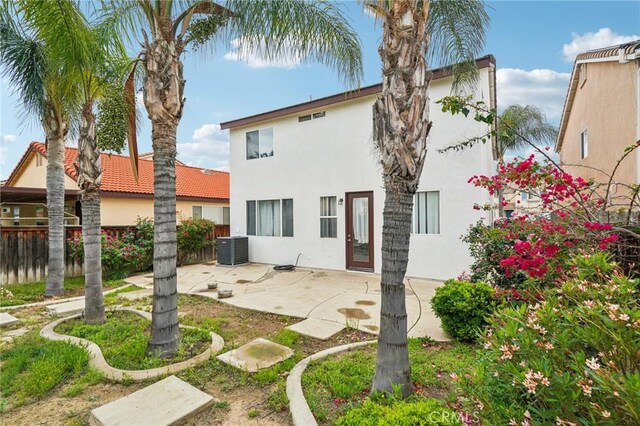 1109 Leopard Ln, Perris, CA 92571 - back of property featuring stucco siding, a patio, and central air condition unit