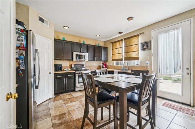 1109 Leopard Ln, Perris, CA 92571 - kitchen featuring stainless steel appliances, light countertops, dark brown cabinetry, a sink, and recessed lighting