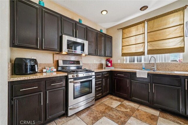 1109 Leopard Ln, Perris, CA 92571 - kitchen with appliances with stainless steel finishes, a sink, and light stone counters
