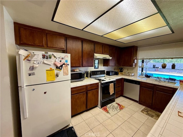 24859 Rock Springs Trl, Moreno Valley, CA 92557 - kitchen featuring stainless steel appliances, under cabinet range hood, tile countertops, a sink, and light tile patterned floors