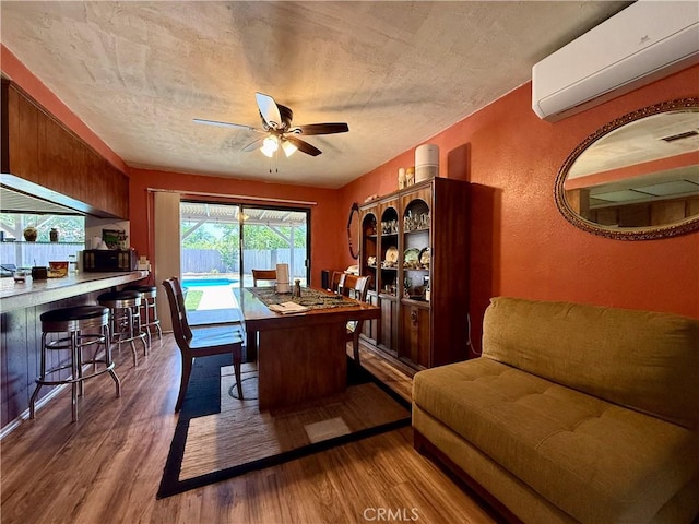 24859 Rock Springs Trl, Moreno Valley, CA 92557 - dining room featuring a wall mounted AC, ceiling fan, wood finished floors, and a textured wall