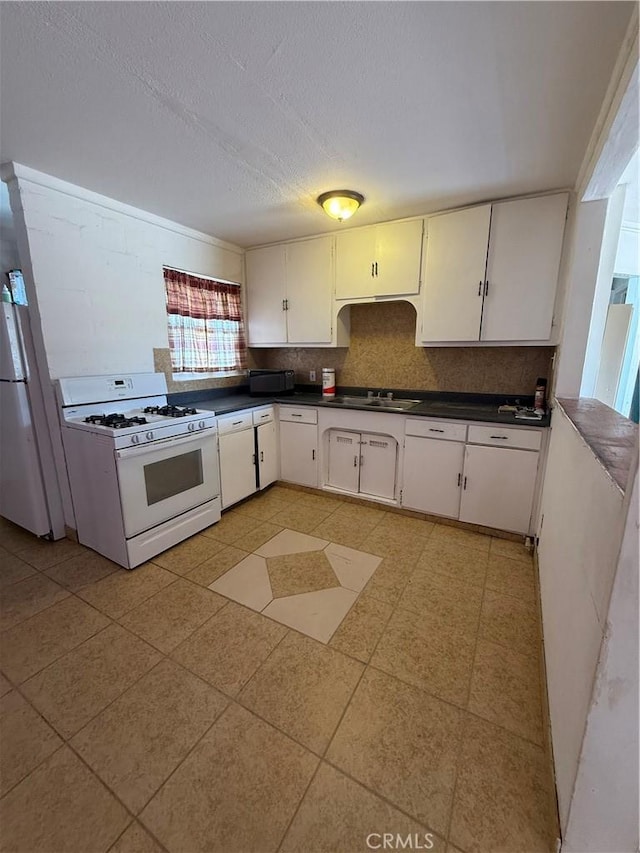 6733 Tamarisk Ave Unit 29, Palms, CA 92277 - kitchen featuring white appliances, dark countertops, a textured ceiling, white cabinets, and backsplash