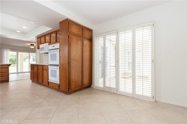 24912 Delos Ave, Mission Viejo, CA 92691 - kitchen with white appliances, a tray ceiling, brown cabinets, light tile patterned floors, and recessed lighting