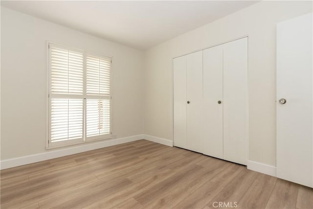 24912 Delos Ave, Mission Viejo, CA 92691 - unfurnished bedroom with light wood-type flooring, a closet, multiple windows, and baseboards