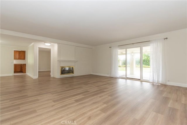 24912 Delos Ave, Mission Viejo, CA 92691 - unfurnished living room featuring baseboards, light wood finished floors, a large fireplace, and crown molding
