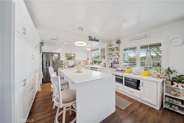 938 Amherst St, Corona, CA 92880 - kitchen featuring stainless steel appliances, a kitchen breakfast bar, dark wood-style flooring, a center island, and white cabinets