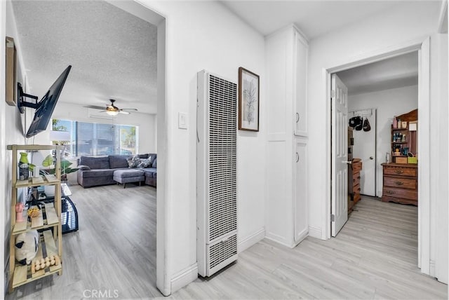 155 N Acacia Ave, Rialto, CA 92376 - hallway featuring a heating unit, light wood-style floors, and baseboards