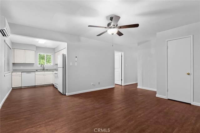 1204 W 5th St, Chico, CA 95928 - unfurnished living room featuring dark wood-type flooring, a wall mounted AC, ceiling fan, and baseboards