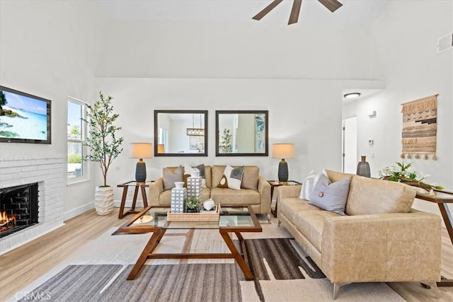 3176 Landmark Ct, Riverside, CA 92503 - living room featuring a towering ceiling, wood finished floors, a ceiling fan, and a brick fireplace
