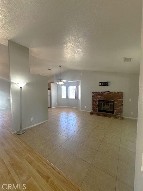 20826 Otowi Rd, Apple Valley, CA 92308 - unfurnished living room with vaulted ceiling, a ceiling fan, a textured ceiling, baseboards, and light tile patterned floors