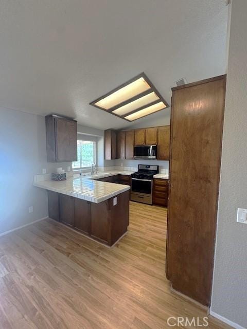 20826 Otowi Rd, Apple Valley, CA 92308 - kitchen featuring stainless steel appliances, a peninsula, light wood-style floors, light countertops, and a sink