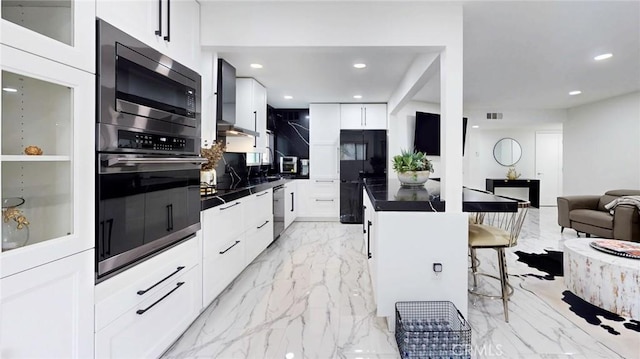 4632 Park Granada Unit 93, Calabasas, CA 91302 - kitchen with dark countertops, appliances with stainless steel finishes, light marble finish floors, a kitchen bar, and recessed lighting