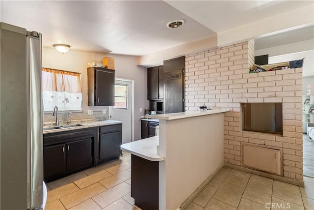 1126 W W Ave H6, Lancaster, CA 93534 - kitchen with freestanding refrigerator, light tile patterned floors, a peninsula, and light countertops