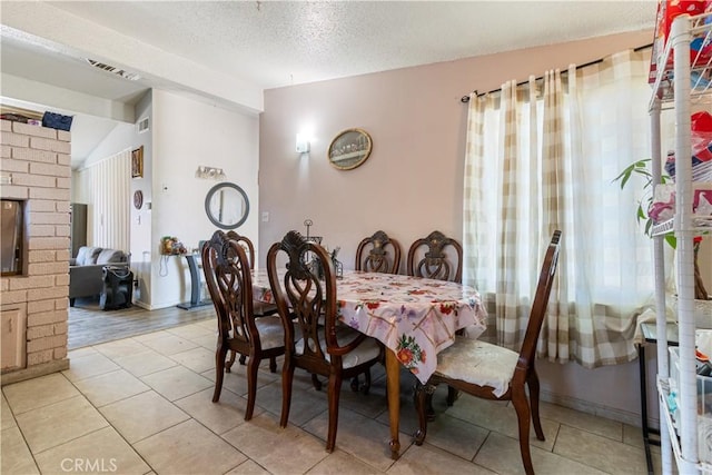1126 W W Ave H6, Lancaster, CA 93534 - dining space with vaulted ceiling, light tile patterned flooring, a textured ceiling, and plenty of natural light
