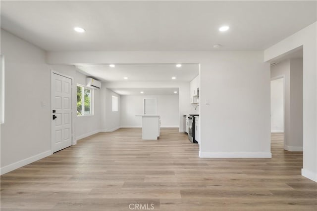 1151 Grand Ave, Colton, CA 92324 - unfurnished living room with a wall mounted air conditioner, recessed lighting, and light wood-style floors