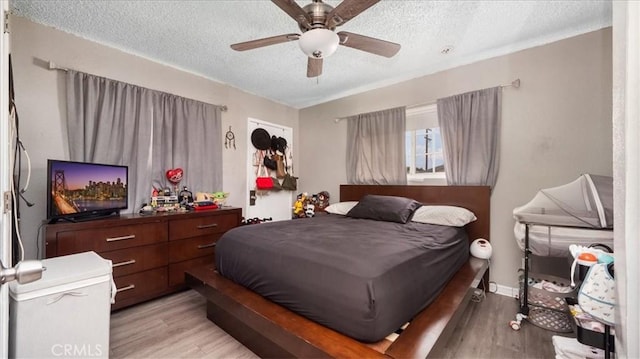 3510 E 2nd St, Los Angeles, CA 90063 - bedroom with light wood-type flooring, a textured ceiling, and ceiling fan