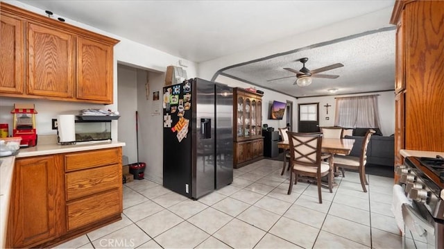 3510 E 2nd St, Los Angeles, CA 90063 - kitchen featuring stainless steel appliances, brown cabinetry, light tile patterned floors, light countertops, and a textured ceiling