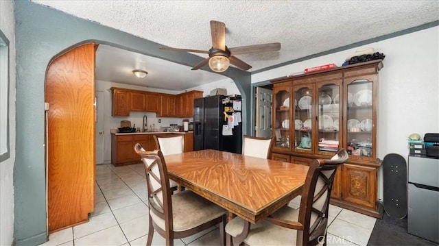 3510 E 2nd St, Los Angeles, CA 90063 - dining room with light tile patterned flooring, a ceiling fan, a textured ceiling, and arched walkways