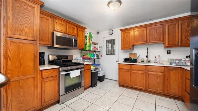 3510 E 2nd St, Los Angeles, CA 90063 - kitchen featuring stainless steel appliances, a sink, light countertops, and brown cabinetry