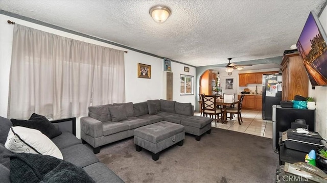 3510 E 2nd St, Los Angeles, CA 90063 - living room featuring arched walkways, a ceiling fan, light carpet, a textured ceiling, and light tile patterned floors