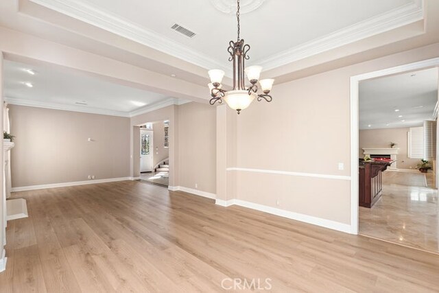 3264 Silver Maple Dr, Yorba Linda, CA 92886 - empty room with ornamental molding, stairs, a chandelier, a lit fireplace, and a tray ceiling