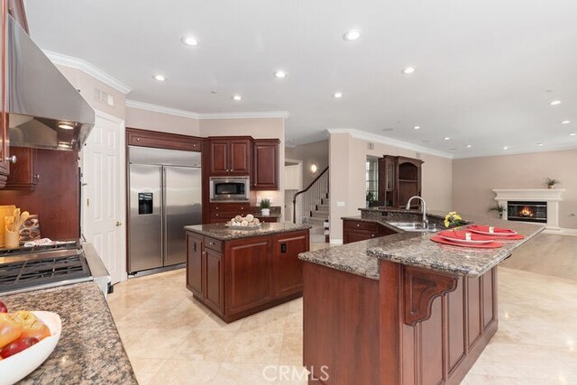 3264 Silver Maple Dr, Yorba Linda, CA 92886 - kitchen featuring built in appliances, a large island, wall chimney exhaust hood, a sink, and ornamental molding