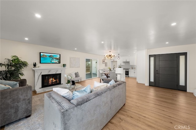 6880 Topaz St, Rancho Cucamonga, CA 91701 - living area with a high end fireplace, light wood-style flooring, recessed lighting, and a chandelier