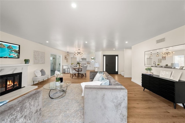 6880 Topaz St, Rancho Cucamonga, CA 91701 - living area featuring a chandelier, a high end fireplace, light wood-style flooring, and recessed lighting