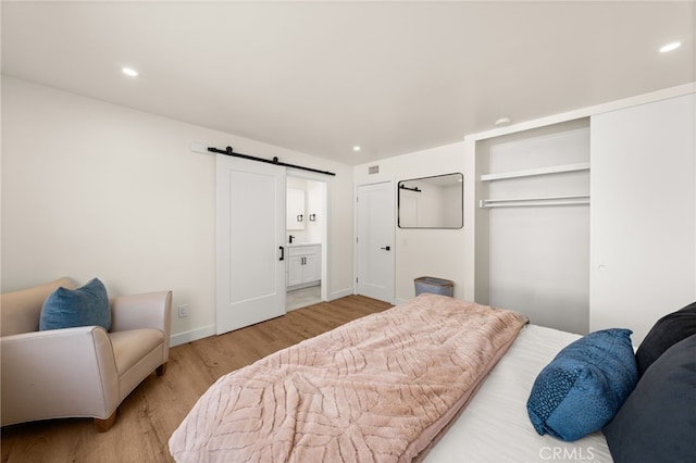 6880 Topaz St, Rancho Cucamonga, CA 91701 - bedroom featuring a barn door, wood finished floors, recessed lighting, a closet, and ensuite bathroom