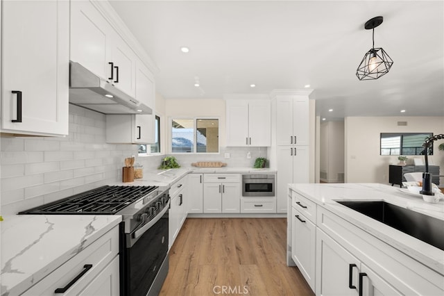 6880 Topaz St, Rancho Cucamonga, CA 91701 - kitchen with gas range, under cabinet range hood, plenty of natural light, backsplash, and recessed lighting