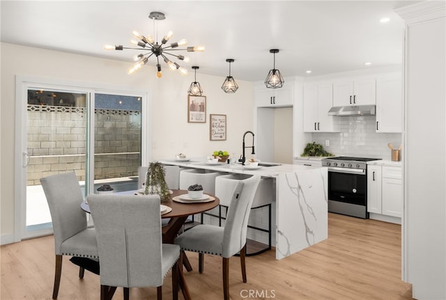 6880 Topaz St, Rancho Cucamonga, CA 91701 - kitchen featuring stainless steel range with gas stovetop, light wood-style flooring, a chandelier, tasteful backsplash, and white cabinetry