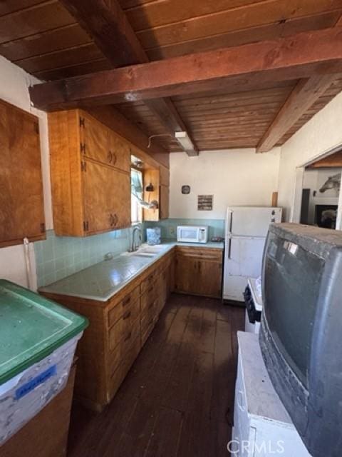 1676 Avalon Ave, Yucca Valley, CA 92284 - kitchen featuring white appliances, dark wood-type flooring, wooden ceiling with exposed beams, brown cabinetry, and decorative backsplash